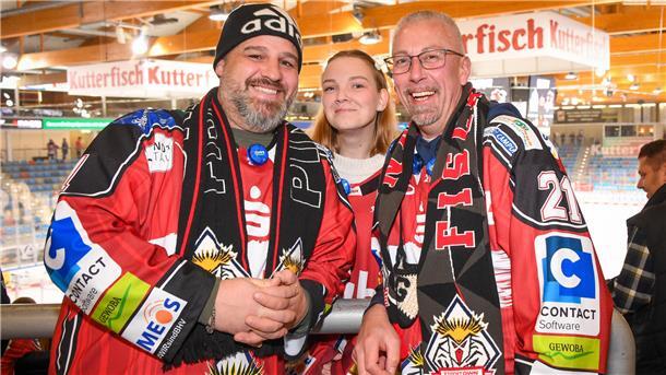 Das sind die Fan-Bilder vom Spiel der Pinguins gegen Iserlohn am Donnerstag Fans lächeln in die Kamera am Rande eines Eishockeyspiels.