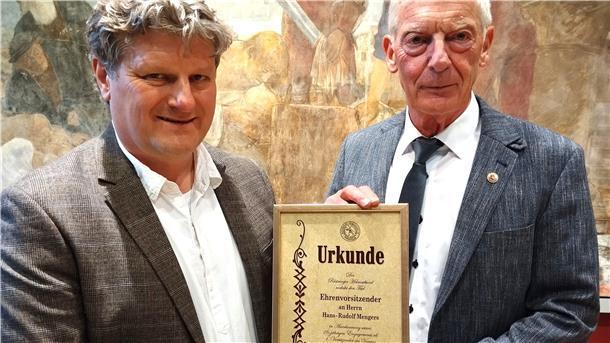 Vorsitzender Karsten Hinrichs (links) überreicht seinem Vorgänger Hans-Rudolf Mengers die Ehrenurkunde.