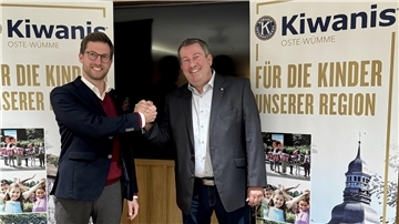 zwei Männer reichen sich die Hände und lächeln