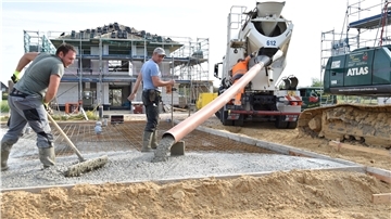 Während der Beton aus dem Mischer läuft, kümmern sich die Betonbauer Michael Pantschuk (links) und Andrej Dukard darum, dass die Masse richtig verteilt wird.