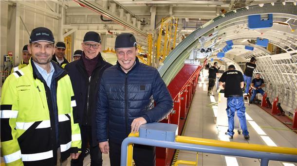 Drei Männer stehen in einer Montagehalle des Unternehmens Airbus Aerostructures in Nordenham-Einswarden.