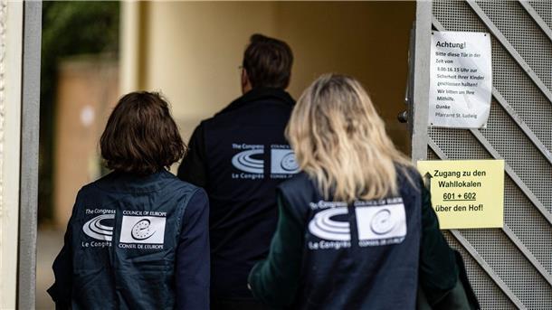 Berlins Wahlleiter zieht positives Fazit Wahlbeobachter des Europäischen Rates betreten ein Berliner Wahllokal.