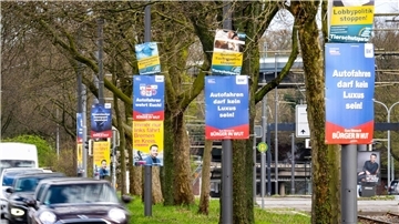 Wahlplakate verschiedener Parteien hängen am Straßenrand.