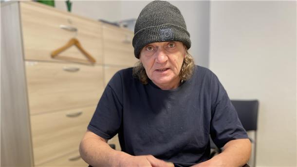 Mann mit Mütze in einem blauen T-Shirt.