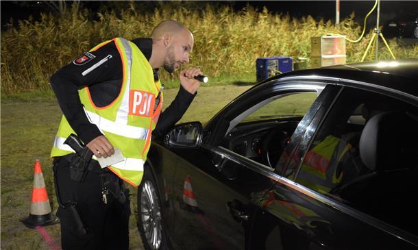 So kontrollierte die Polizei am Wesertunnel 250 Autos Großkontrolle am Wesertunnel: Einsatzleiter Marius Masia blickt mit der Taschenlampe ins Innere eines Fahrzeugs.