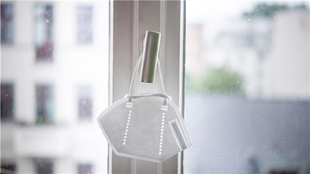 So entscheidet das Gesundheitsamt: Wann muss man in Quarantäne? Eine Maske hängt an einem Fenstergriff.