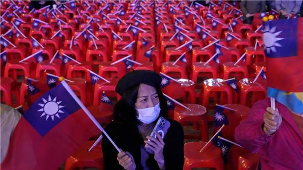 Taiwan wählt China-Kritiker zum Präsidenten Warten auf das Ergebnis der Wahl: Eine Frau schwenkt die Nationalflagge von Taiwan.