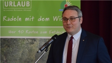 Marco Prietz steht vor einem Mikrofon.