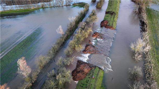 Keine Entwarnung in Hochwasser-Gebieten Wassermassen fließen durch die Deichöffnung am Fluss Helme im nordthüringischen Kyffhäuserkreis auf die umliegenden Flächen.