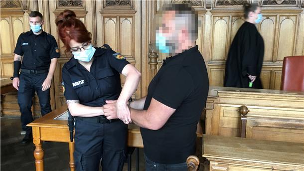 Kokain im Hafen: Haftstrafe für Kurier Polizistin legt einem verdächtigen Mann Handschellen an.