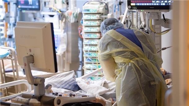 Ein Krankenpfleger versorgt einen Menschen auf der Intensivstation.