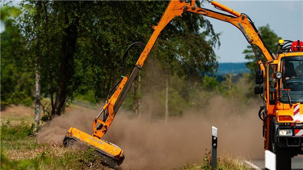 Mit einem Unimog wird der Grünstreifen an einer Kreisstraße gemulcht.