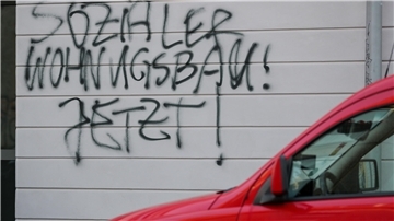 Ein Graffiti «Sozialer Wohnungsbau! Jetzt!» steht an einem neuen Mietshaus einer Wohnungsbaugenossenschaft.