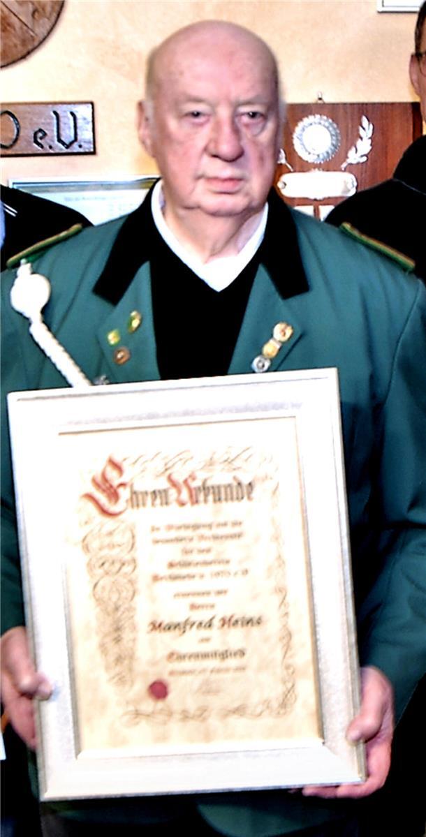 Manfred Heins hält die Urkunde für seine Ernennung zum Ehrenmitglied des Schützenvereins Bexhövede