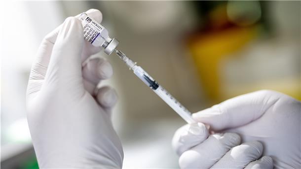 Eine Mitarbeiterin eines Impfbusses zieht während einer Impfaktion den Covid-19-Impfwirkstoff Comirnaty von Biontech/Pfizer auf eine Spritze.