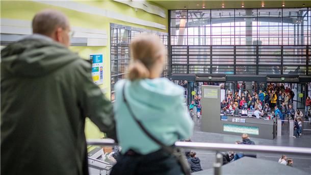 Zwei Personen schauen vom Rang auf den Eingang des Klimahauses