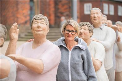 Frau zwischen lauter Beton-Figuren