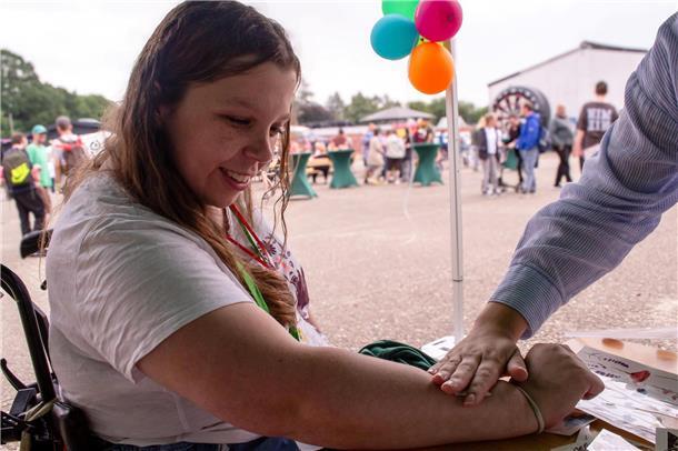 Werkstatt-Beschäftigte der Lebenshilfe feiern Sommerfest Werkstatträtin und Beschäftigte Julia Zimmermann lässt sich ein Glitzer-Tattoo aufkleben.