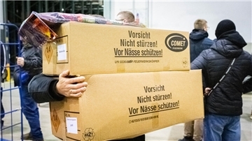 Ein Mann schleppt Kartons. 