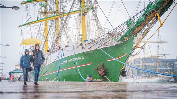 Wetterfeste Menschen lassen sich auch durch den Regen nicht von einem Gang entlang der Schiffsliegeplätze bei den Maritimen Tagen abhalten.