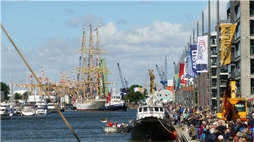 Kaje mit Menschen, Schiff fährt durch Schleuse.