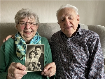 Ehepaar auf Sofa mit Hochzeitsbild