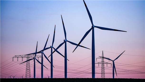 Deutschland wird beim Umbau des Strommarkts überholt Windkraftanlagen und Hochspannungsleitungen sind vor dem Abendhimmel bei Leuna zu sehen.