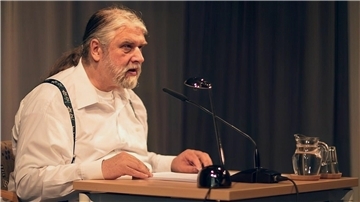 Mann sitzt an Tisch