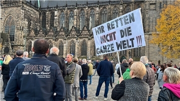 „Wir retten nicht die ganze Welt“ steht auf dem Schild, das Menschen bei einer Demonstration tragen.