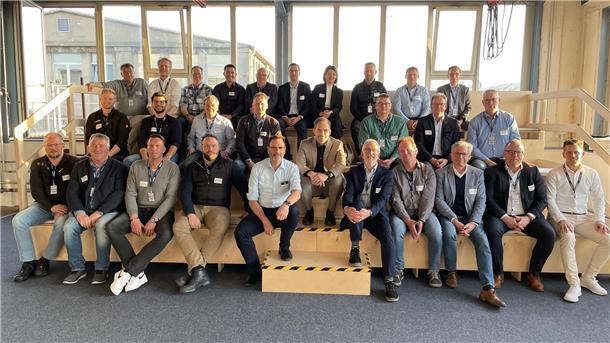 Eine größere Gruppe von Wirtschaftsvertretern und Airbus-Mitarbeitern sitzt zusammen.