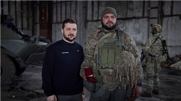 Wolodymyr Selenskyj steht neben einem Soldat anlässlich einer Verleihungszeremonie in einer Stellung in der Nähe von Bachmut.
