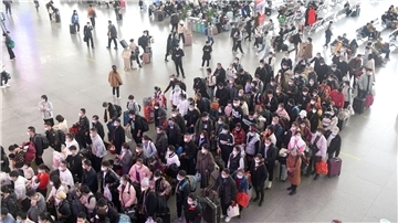 Zahlreiche Fahrgäste stehen in einem Bahnhof in der südchinesischen Provinz Guangdong Schlange.