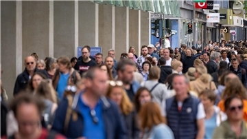 Zahlreiche Menschen gehen an den Geschäften in Berlin vorbei.
