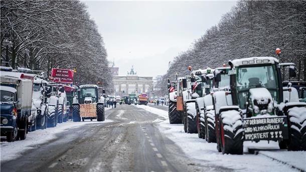Grüne Woche gestartet - Wut der Landwirte hält an Zahlreiche schneebedeckte Traktoren stehen auf der Straße des 17. Juni vor dem Brandenburger Tor in Berlin.