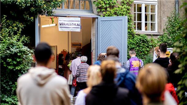 Zahlreiche Wählerinnen und Wähler warten im Berliner Stadtteil Prenzlauer Berg in einer langen Schlange vor einem Wahllokal, das in einer Grundschule untergebracht ist.