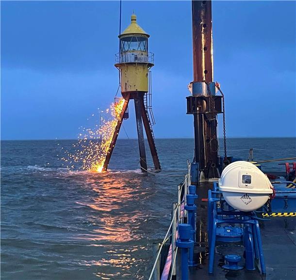 Das gelbe Kopfteil des Seezeichens, bestehend aus Gaskessel und Laternenraum, wird abgetrennt.