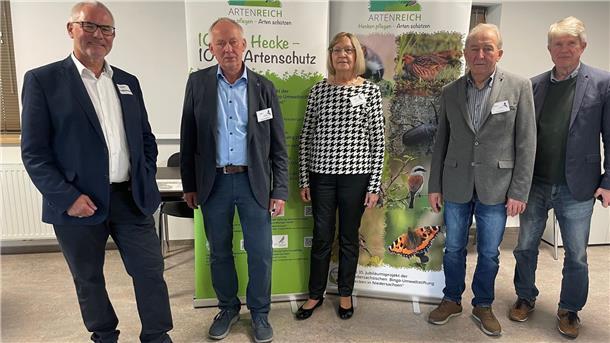 Vier Männer und eine Frau stehen nebeneinander vor großen Aufstellern über Hecken und Artenschutz.