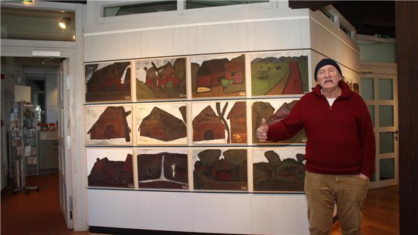 Alexander Dettmar vor einer Bilderreihe in seiner Ausstellung