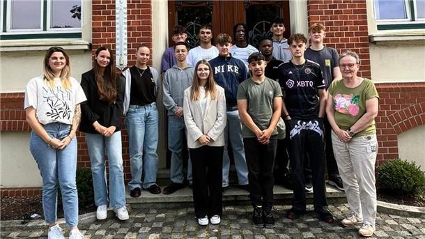Bei Prysmian Nordenham beginnt für 13 junge Menschen die Ausbildung Mehrere junge Menschen stehen vor einem Backsteingebäude.