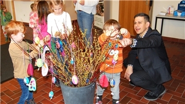 Zur Freude des Ersten Gemeinderates Martin Leying (rechts) dekorierten die Kids der Kita „Dachbau“ Forsythien-Zweige und Fenster im Hagener Rathaus mit selbst gebasteltem Osterschmuck. Foto: Heß