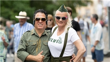 Zwei Besucher des Elvis-Festivals laufen über das Freigelände.