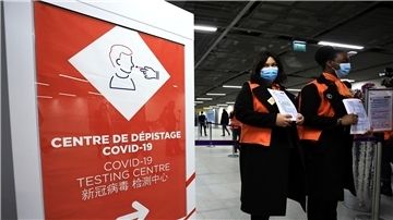 Zwei Flughafenmitarbeiterinnen warten auf dem französischen Flughafen Roissy-Charles de Gaulle auf Passagiere aus China.