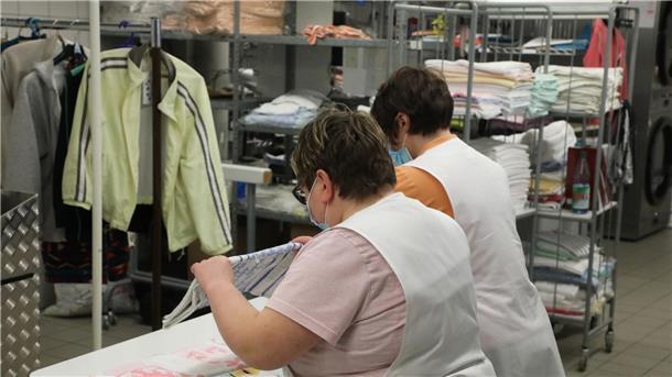 Studie sieht Benachteiligung von Menschen mit Handicap Zwei Frauen arbeiten in der Wäscherei der Lebenshilfe Gera e.V und legen dort Wäsche zusammen.