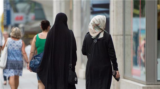 Zwei Frauen mit Kopftuch und langer Oberbekleidung.