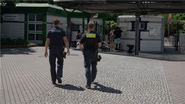 Auseinandersetzung im Berliner Prinzenbad Zwei Polizsten der Mobilen Wache gehen auf das Prinzenbad in Kreuzberg zu.