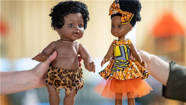 Zwei Puppen werden im Spielzeugmuseum Nürnberg gehalten. Die Puppe links im Bild hat schwarze Haut und trägt nichts als einen Lendenschurz mit Leopardenmuster. Sie habe aber die Gesichtszüge einer hellhäutigen Puppe, sagt eine Mitarbeiterin vom Spielzeugmuseum in Nürnberg. Die Puppe rechts hingegen wirke modern.