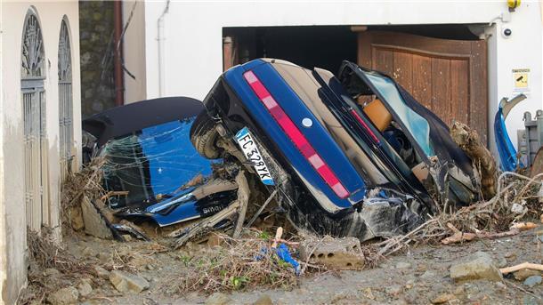 „Eine Tragödie“: Sieben Tote nach Unwettern in Ischia Zwei von Schlamm bedeckte Autos liegen vor einen Wohnhaus.
