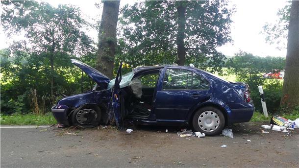 Ein verunfalltes Auto, das gegen einen Baum geprallt ist. 